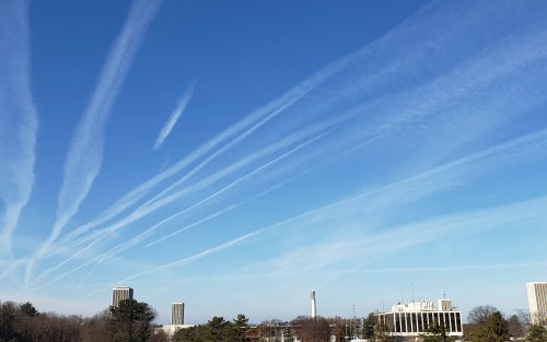 Contrails cover a blue sky above UAlbany's Uptown Campus. 