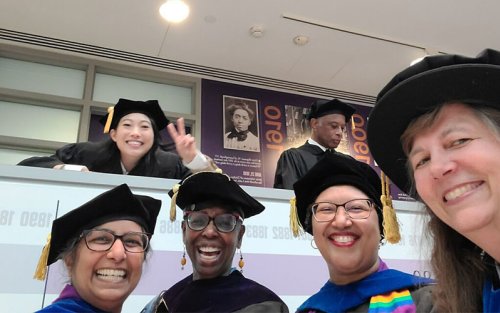 Nora Lum smiles and poses with WGSS faculty at the UAlbany commencement ceremony.