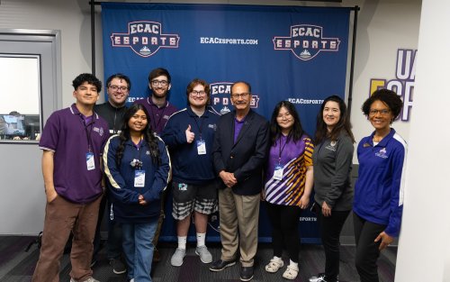 President Rodriguez stands with the UAlbany Esports team in front of an ECAC Esports banner.