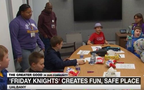 Students and staff working at a table.
