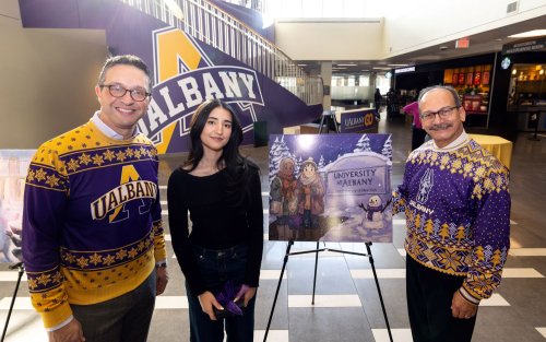 Student stands with President and Vice President with her winning artwork
