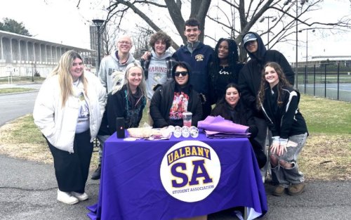 Student Association students huddle around a table.