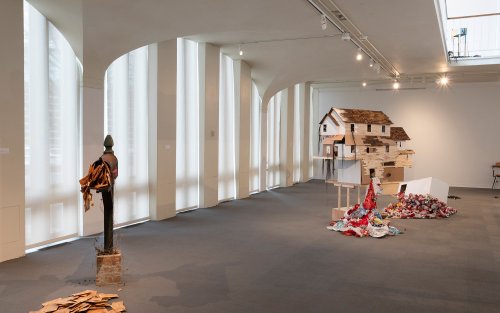 A mailbox, its mail spilling out onto the floor, and a scaled-down model home occupy the UAlbany Museum's Exhibition Space.