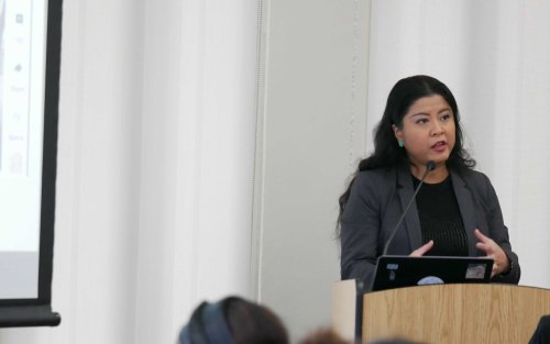 Titcha Ho stands at a lectern during her presentation on "AI as Your Writing Partner: Practical and Ethical Strategies for Academic Success."