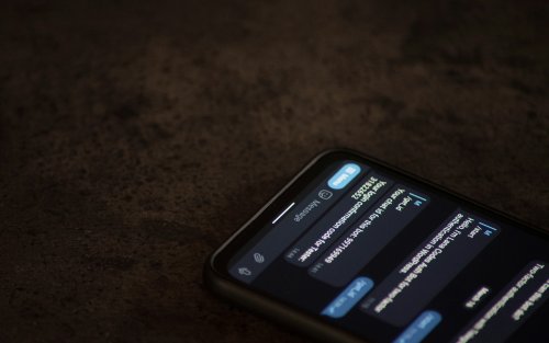 A phone is open on a brown surface with a chatbot conversation on the screen.