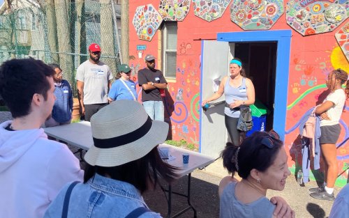 A group of volunteers stand outside the West Hill Refugee Welcome Center.