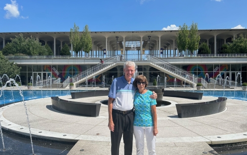  Donna Brown '78 and her spouse, Ted, pose at the main fountain during a campus visit in 2023.