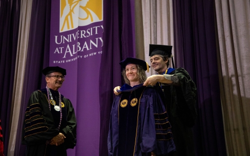 Doctoral student being hooded by advisor.