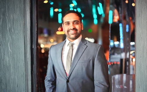 A smiling Rajas Mathkari in a gray suit with a white shirt. 