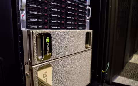 A close-up of a silver rectangular GPU system installed in a row of tall, black server racks. 