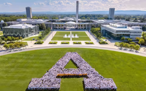 Hundreds of UAlbany students stand in the shape of a large A on the field of Collins Circle