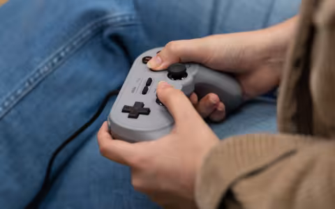 A student plays with a retro controller inside the Game Hub.