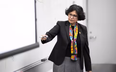 Rita Biwas Business Professor standing in front of a class.