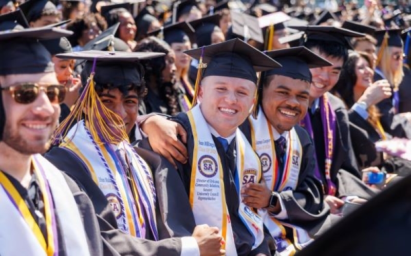 A crowd of graduates in graduation caps and gowns.
