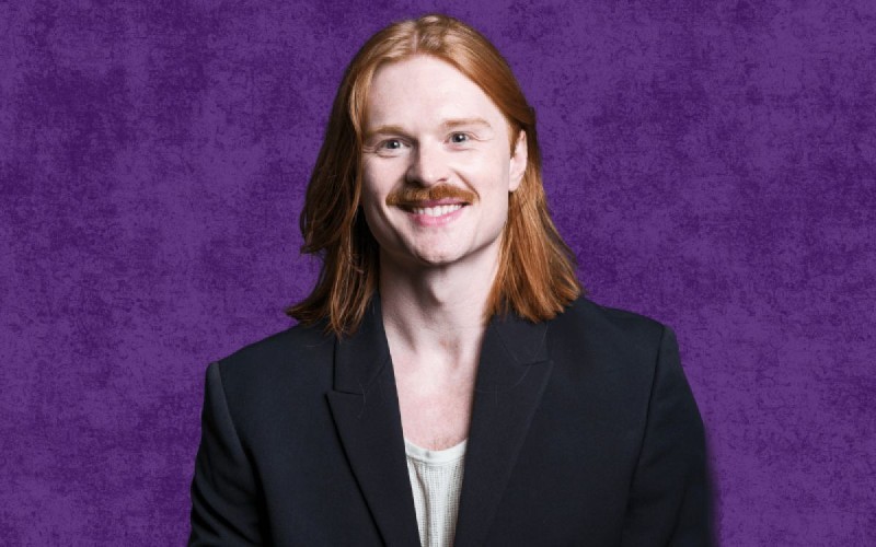 a red-headed man in a black jacket