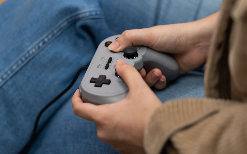 A student plays with a retro controller inside the Game Hub.