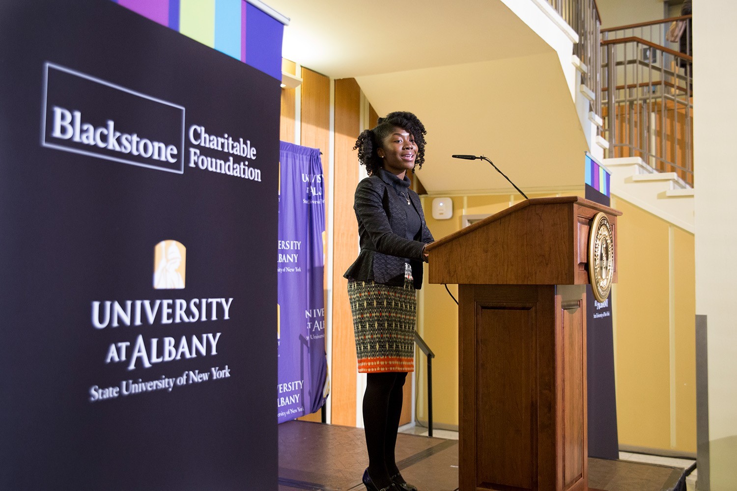 A student speaking at a podium about Blackstone Launchpad.