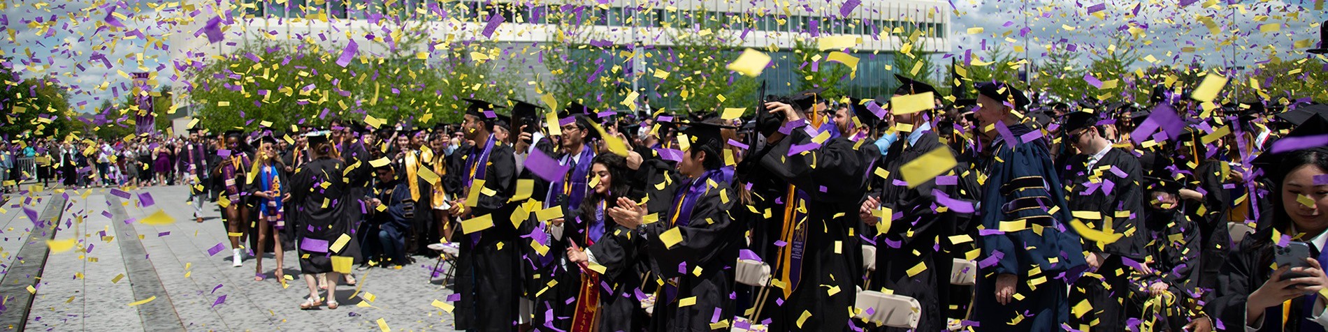 Confetti falling on robed students at the commencement ceremony