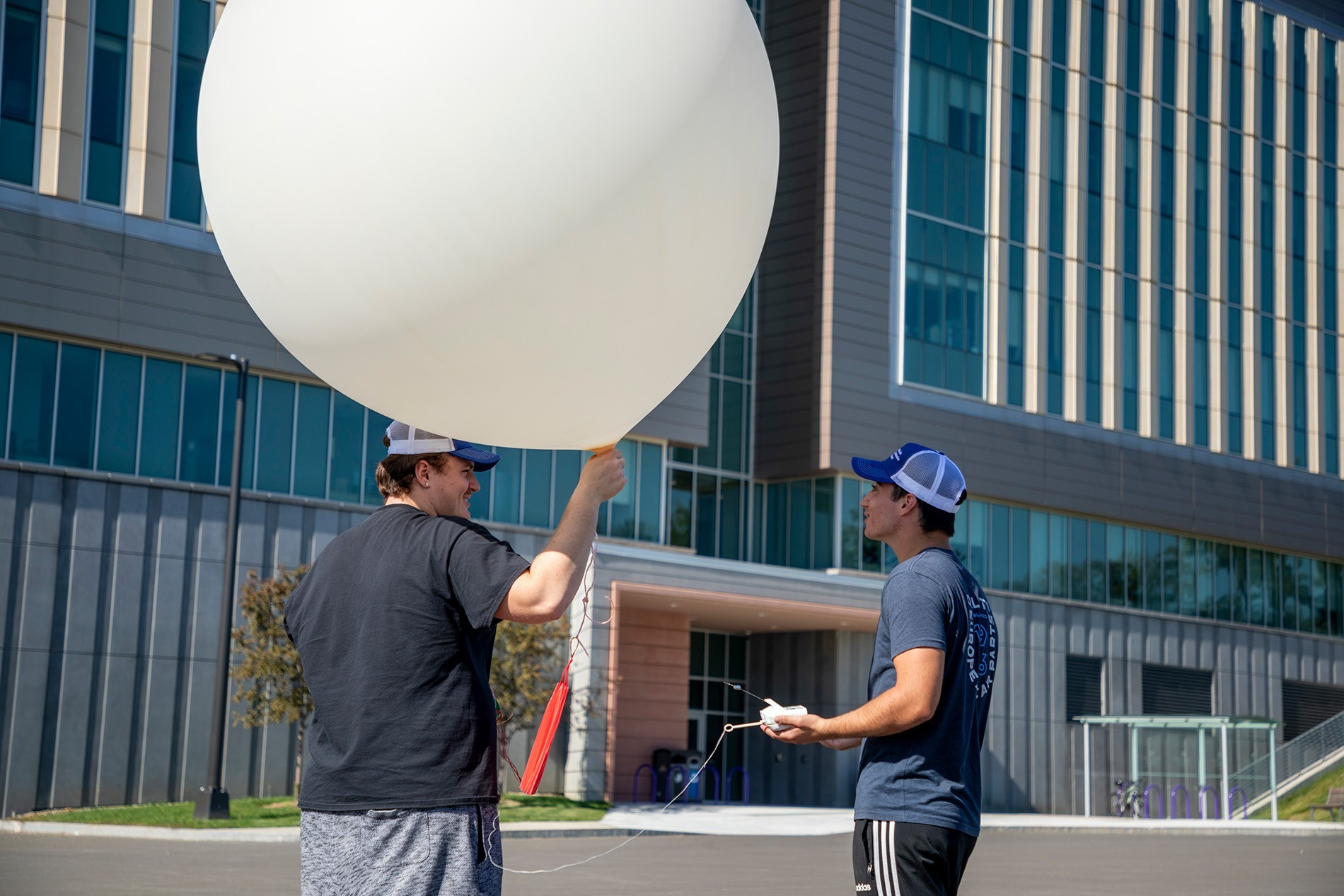 DAES students prepare a weather balloon for a practice launch from the ETEC parking lot.