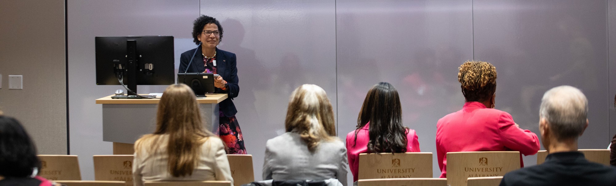 CEMHD Director Elizabeth Vásquez speaks to a seated audience.