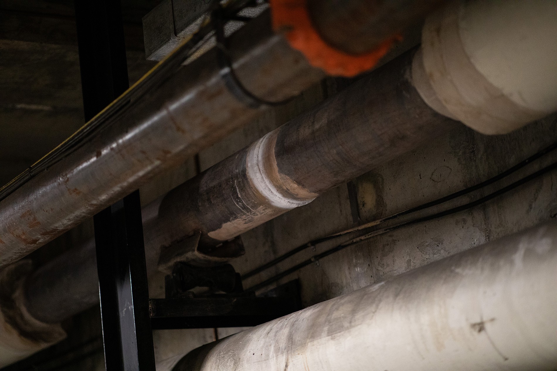 A photo of a metallic gray pipe with a a white ring showing a recent weld.