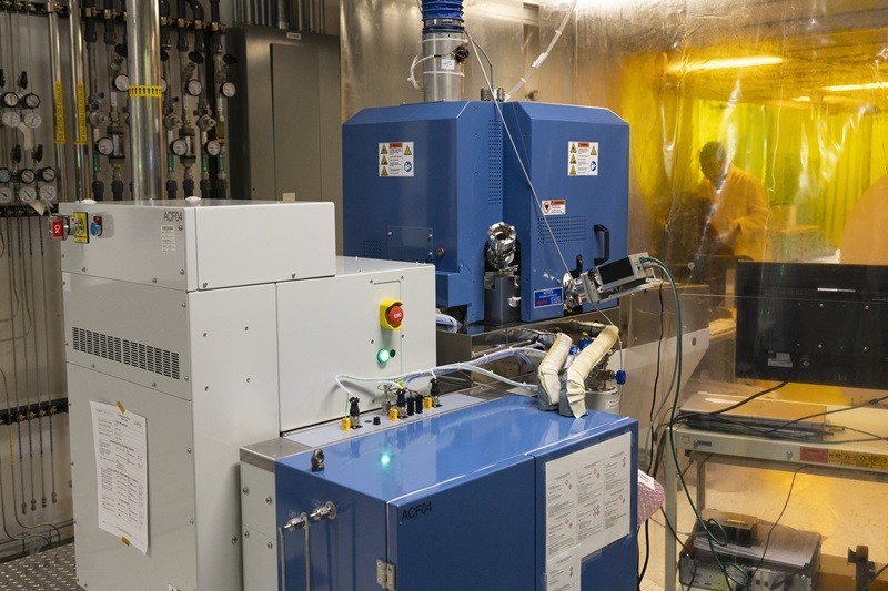 A photo of a gray and blue piece of laboratory equipment the size and shape of several washing machines.
