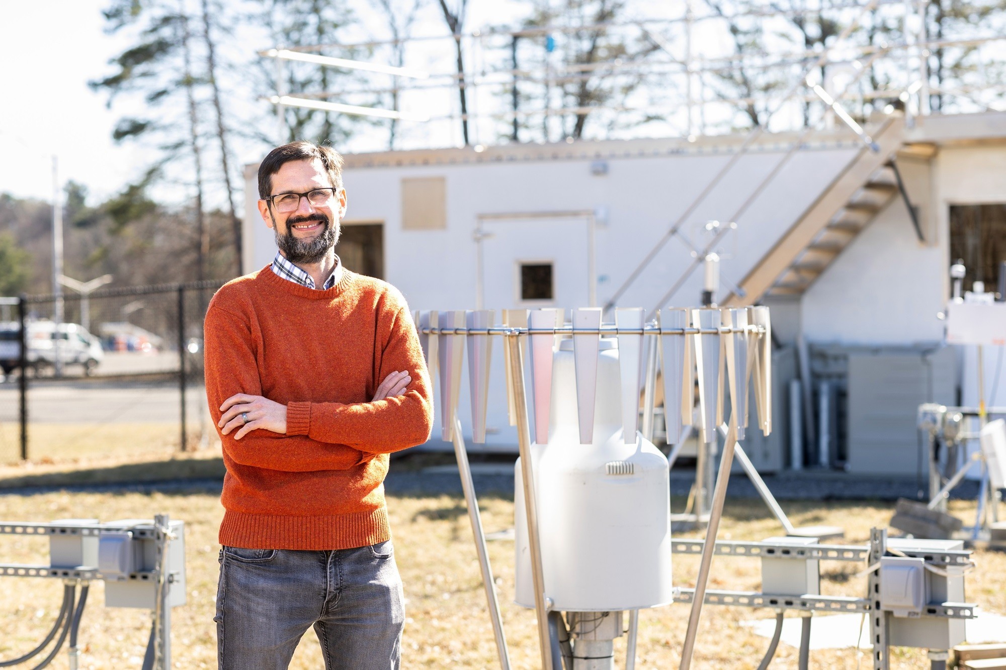 Justin Minder stands in front of Mesonet instrumentation at the ETEC yard.