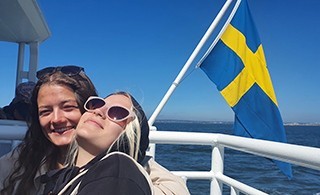 Two young women on the deck of a ship in open waters
