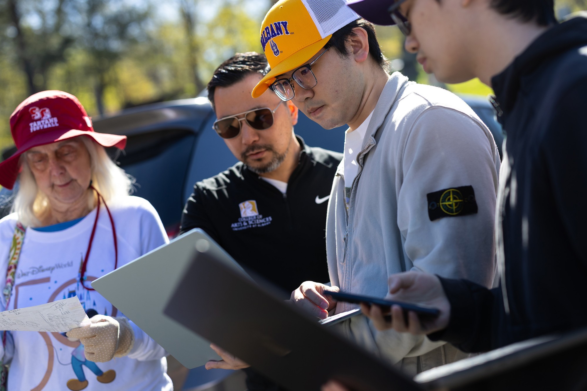 M. Patricia Parker of Guilderland, left, stands with UAlbany Associate Professor Rui Li and students Micah Wang and Weiming Lan at Albany Rural Cemetary.