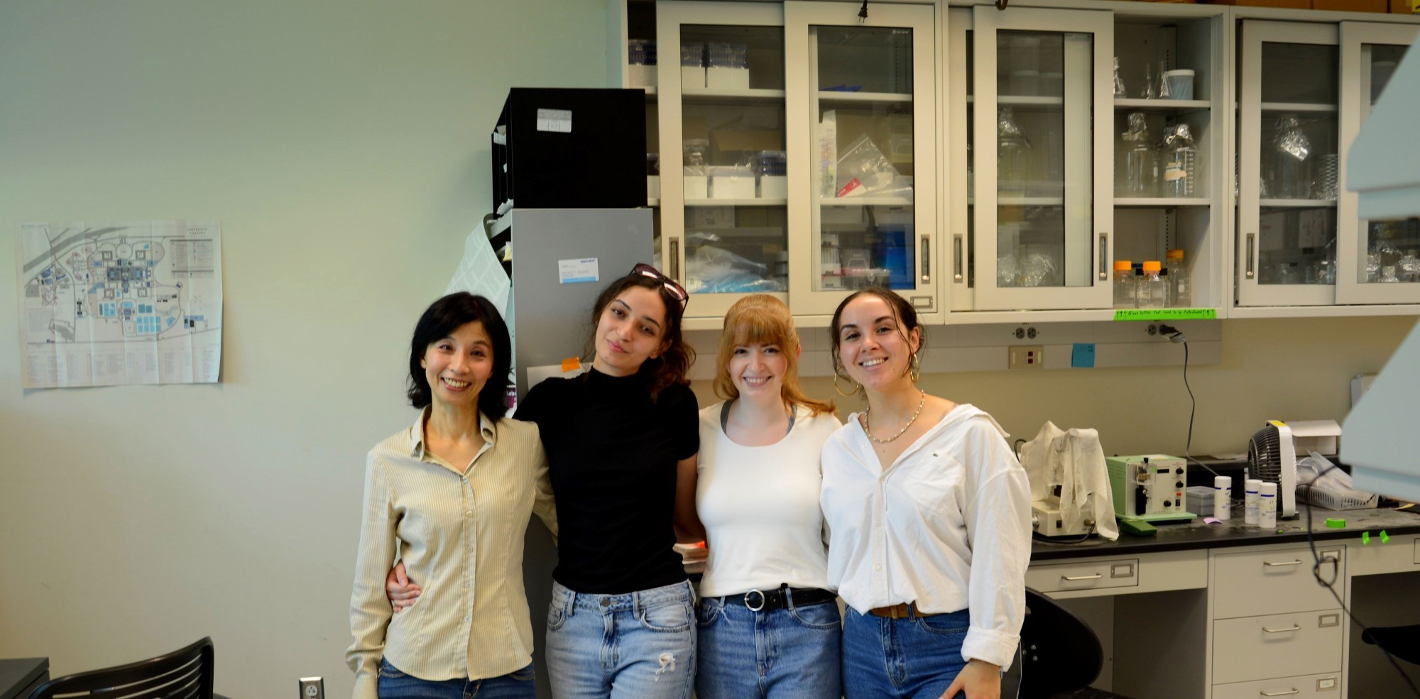 Research Scientist Megumi Akamatsu and three student researchers smile and pose for a photo inside the Niu Research Laboratory.
