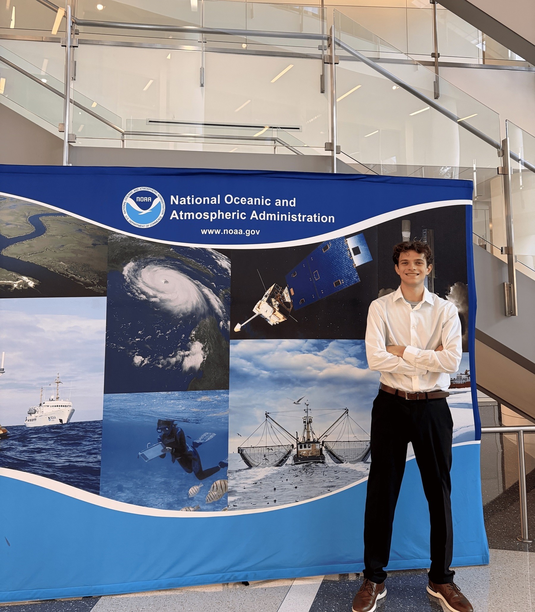  Michael Miller stands in front of a NOAA step and repeat banner.