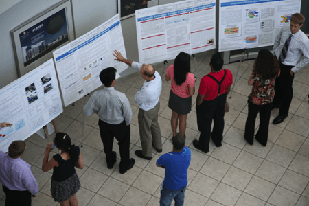 Faculty and student view posters at the poster presentation
