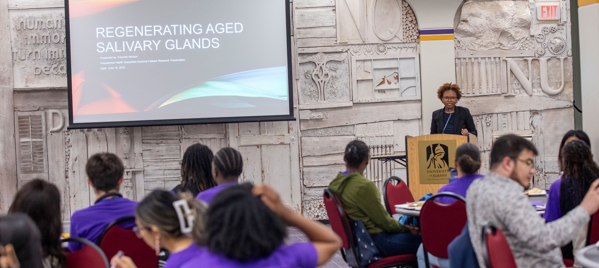 Health disparities doctoral fellow Kennedi Weston presents a slide titled, "Regenerating Aged Salivary Glands."