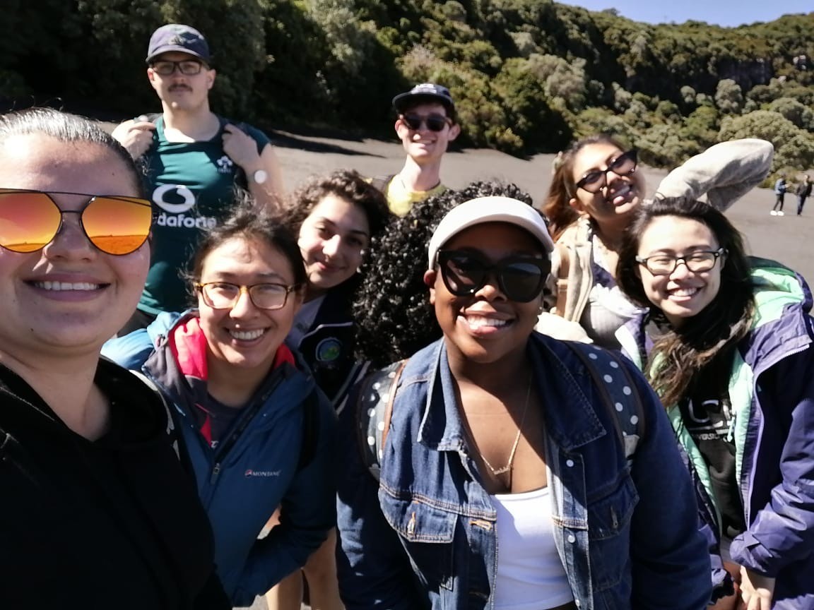 A group of students pose for a selfie outside. 