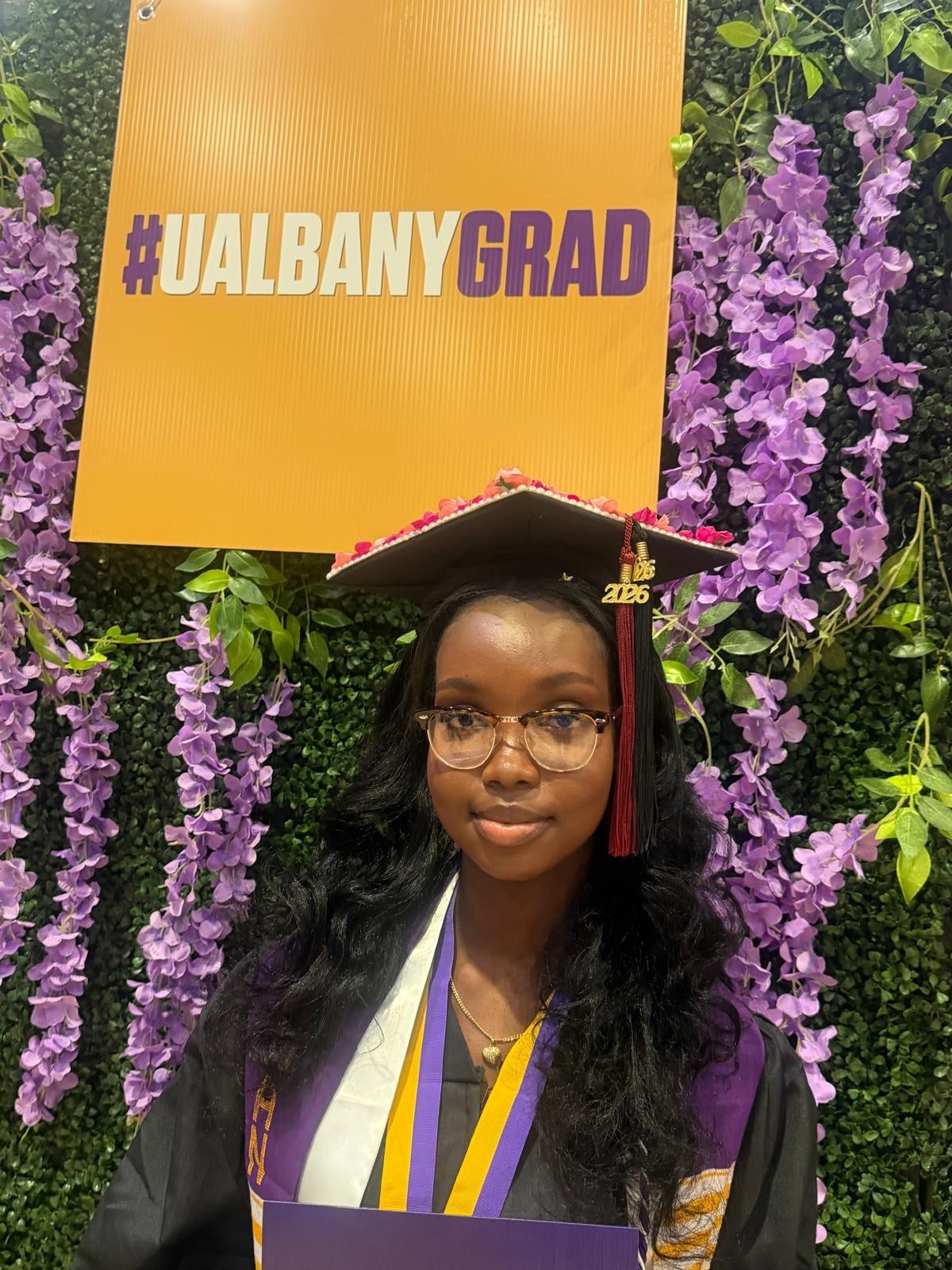 Barbara Origene '25 celebrates at UAlbany's 2025 commencement stage crossing event.