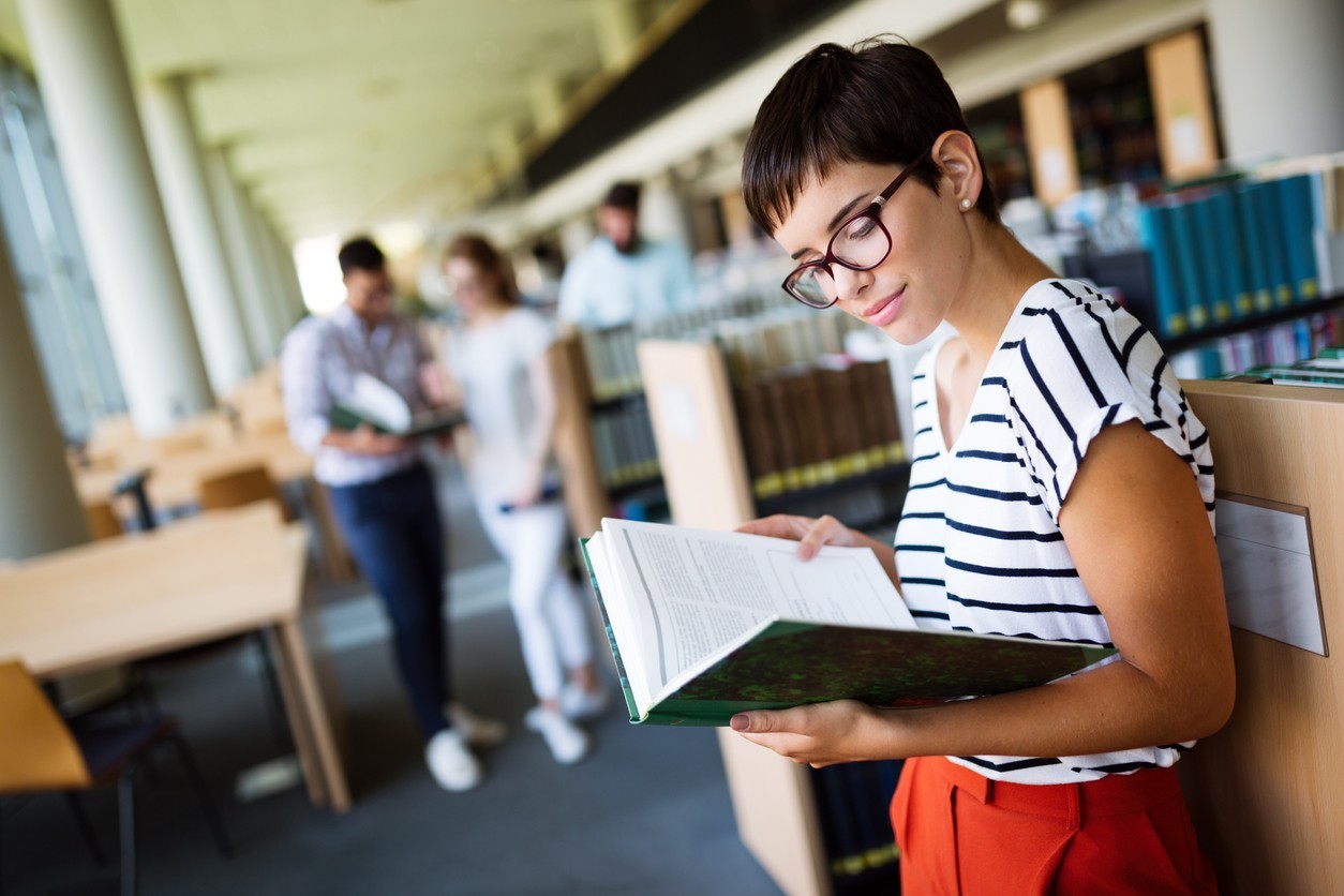 Student reading a book in the library