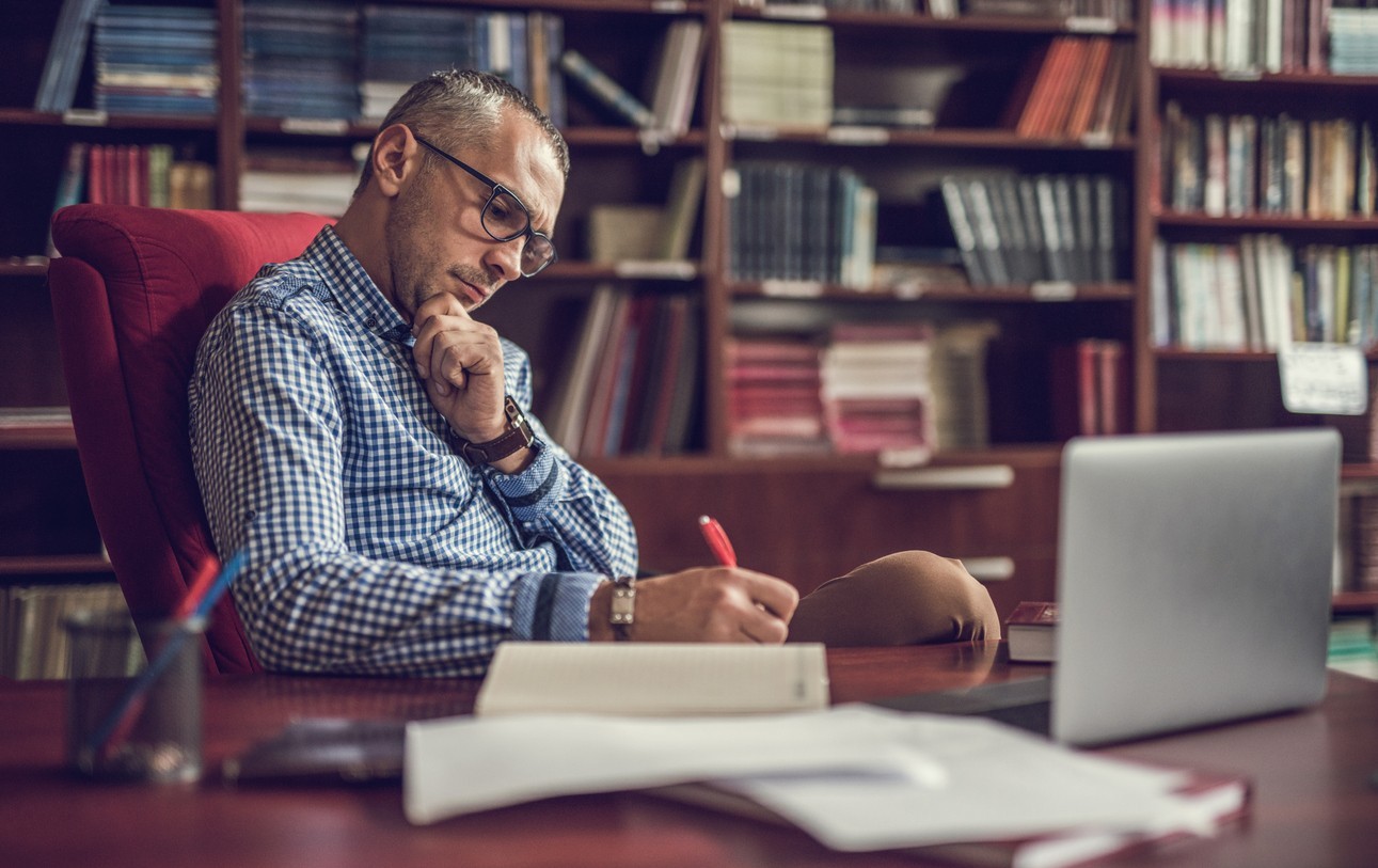 A man making notes in his home office