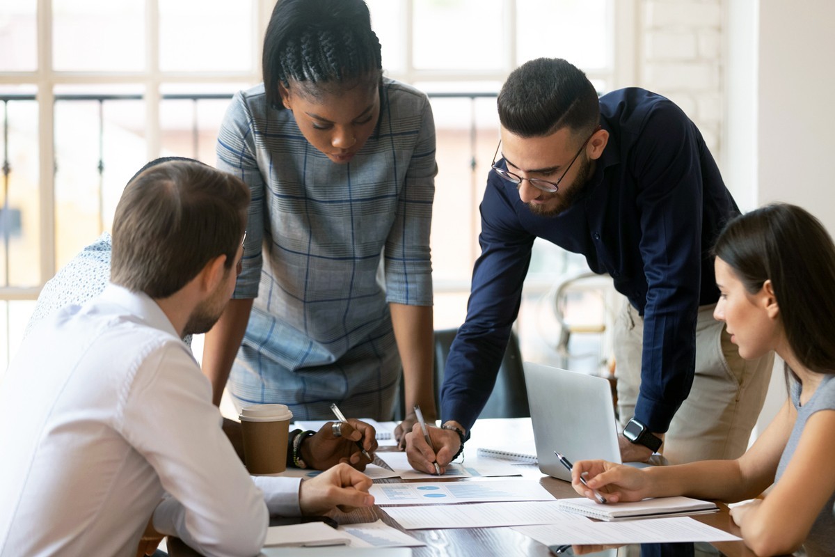 A group of young professionals working on a project at a conference table.