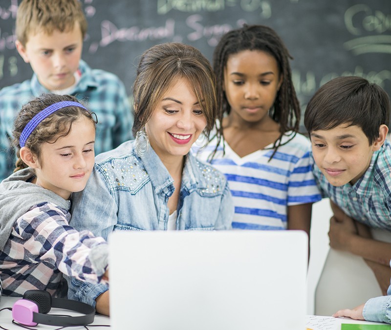 Teacher and students working on a computer