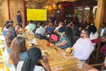 A group of UAlbany MBA students sitting at a table at Dengo Chocolates in Brazil.