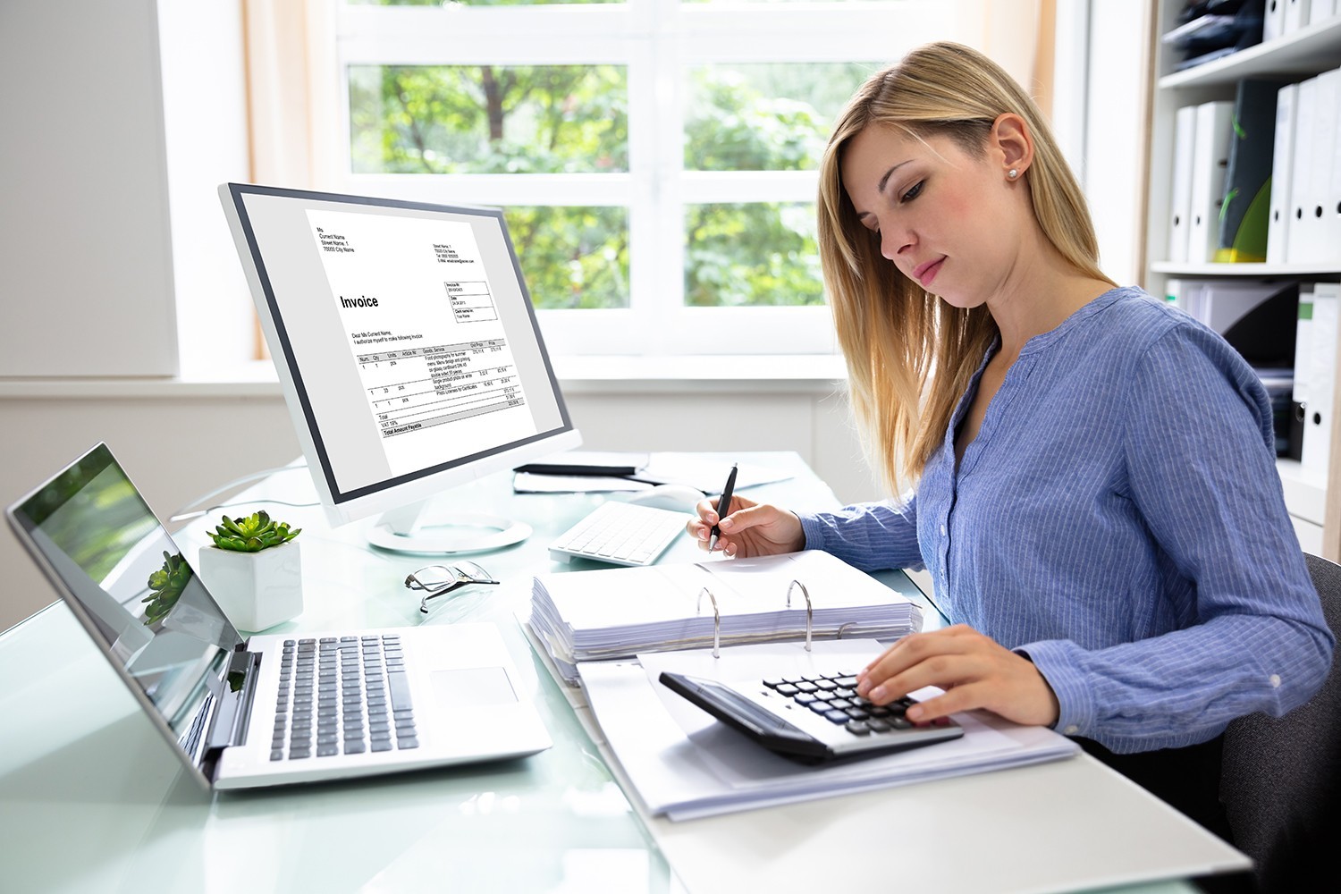 young businesswoman calculating bill