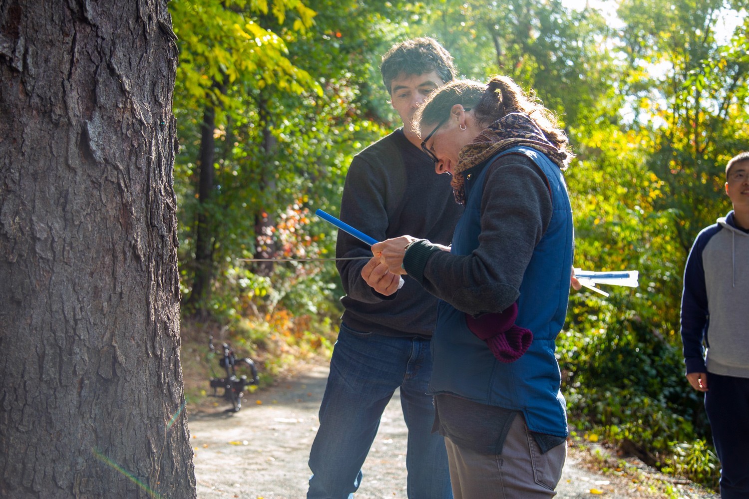 A UAlbany student and professor conducting field research in a forrest.