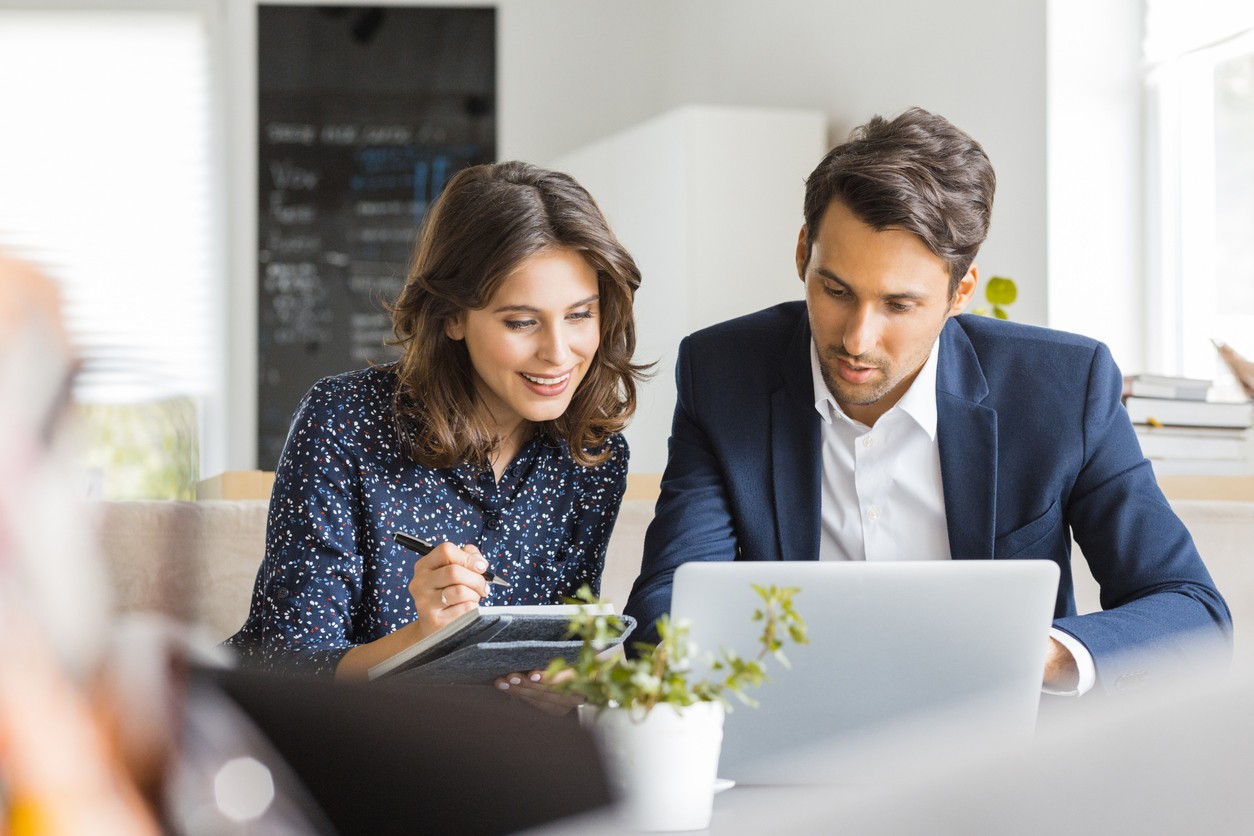 Two professionals working on a laptop