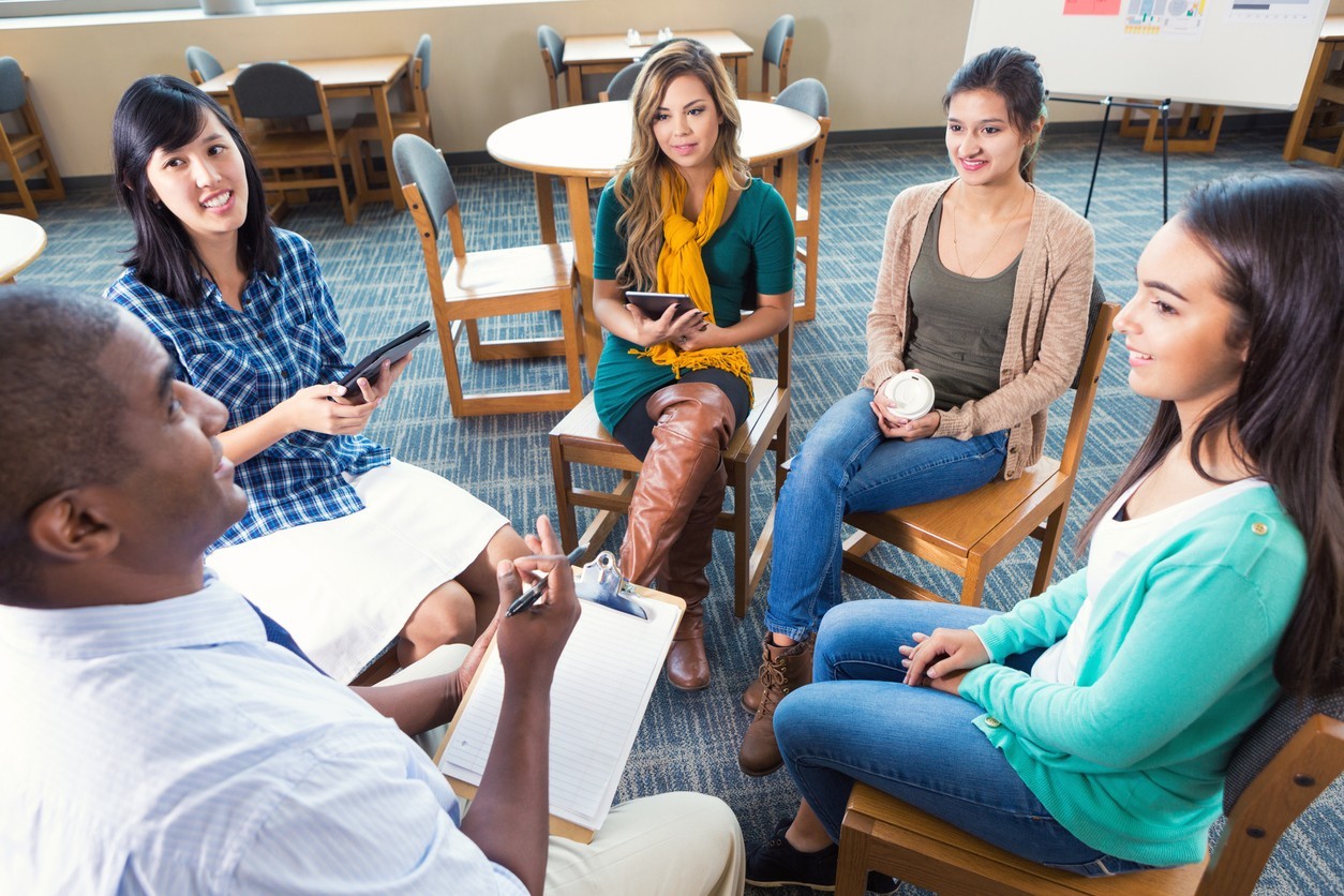 Five young adults in a group discussion