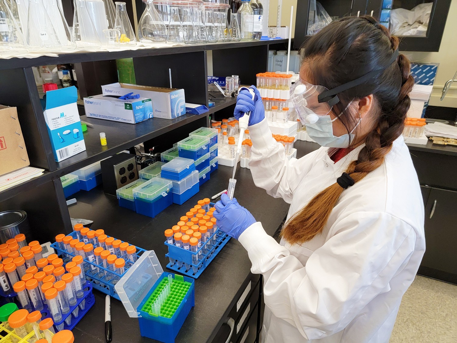 A researcher working with test tubes in the UAlbany CNSE lab.