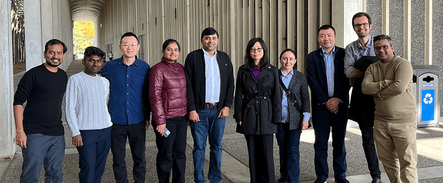 A group of ten researchers, including Dr. Yann Liang, stand and pose, smiling for a photo.