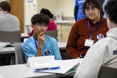 Students and instructors gather around a table