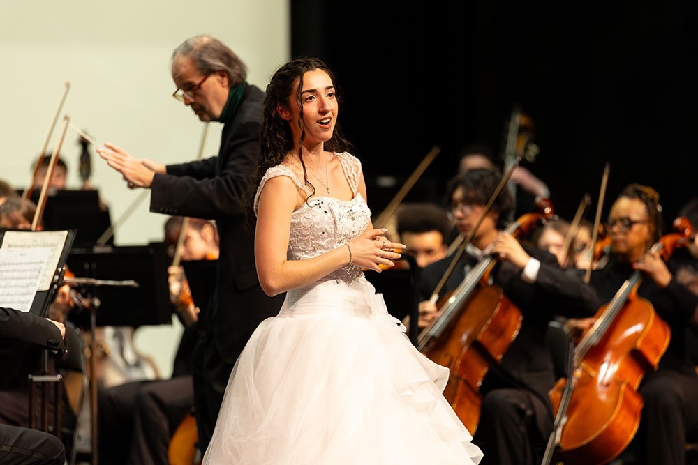 Performer singing with the University Orchestra.