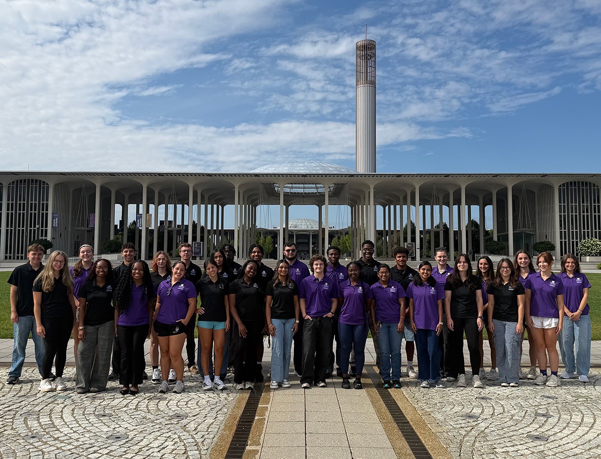 A group of students and staff members posed in front of the podium.