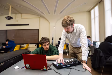 Thomas Wilson uses a MIDI keyboard to interact with a student in his game design course.